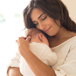A mother holding her baby close to her chest after a successful breastfeeding session