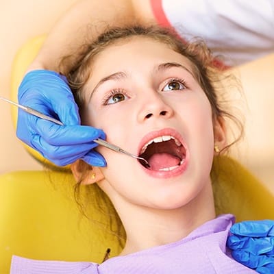 Teen girl receiving dental exam