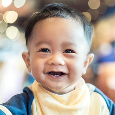 A baby with two bottom teeth showing