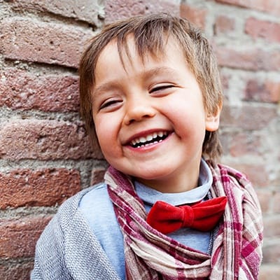 Laughing little boy with red bowtie