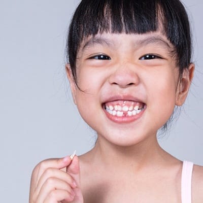 A young girl smiling with a missing tooth