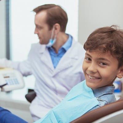 A young boy smiling in the dentist chair