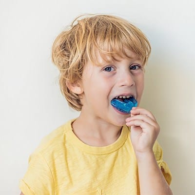 Child placing mouthguard