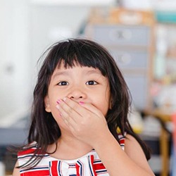 Surprised little girl covers her mouth