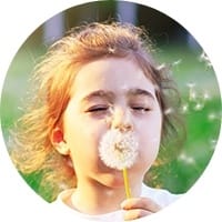 Little girl blowing dandelion