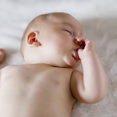 Sleeping baby sucking thumb