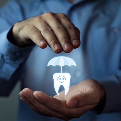 Hand holding animated tooth and umbrella