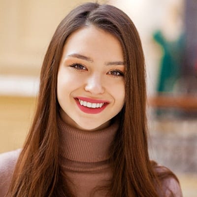 A young girl with dark hair smiling