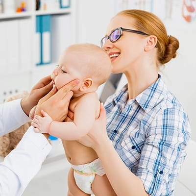 Mother holding child during dental exam