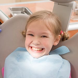 Smiling young girl in dental chair