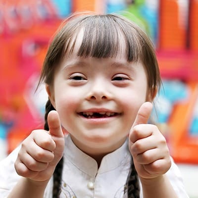 Smiling little girl giving two thumbs up