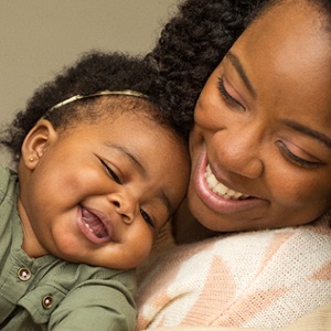 A mother hugging her baby after having undergone a successful frenectomy to release the infant’s lip and tongue tie