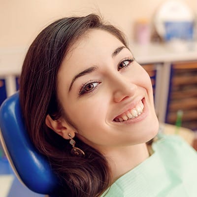 Smiling young woman in dental chair