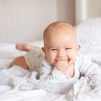 A baby chewing on its fingers