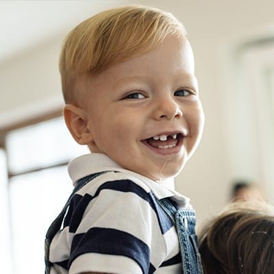 Smiling little boy with missing front tooth