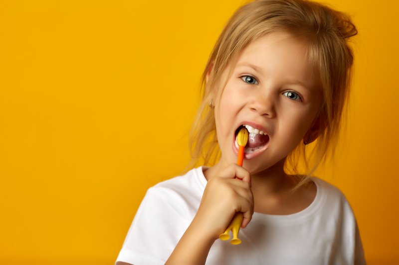 a little girl brushing her teeth