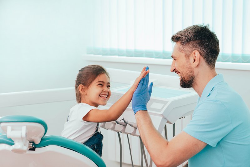 a little girl giving her dentist a high-five