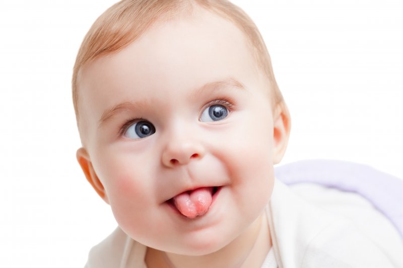 a baby sticking its tongue out and smiling
