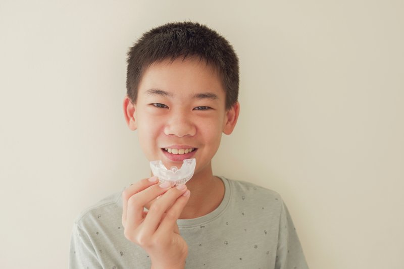 young boy holding mouthguard for kids in McKinney 