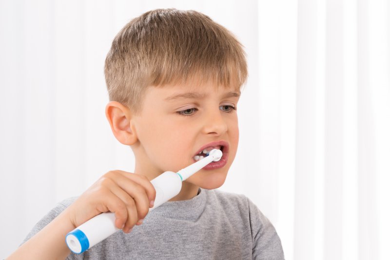 boy using an electric toothbrush