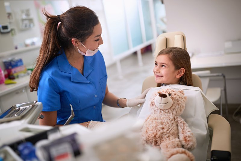 a young girl smiling at her pediatric dentist