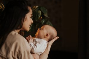 mom holding newborn baby who has a lip or tongue tie