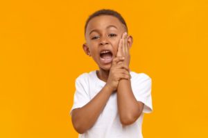 child holding a thumbs up for root canals for kids