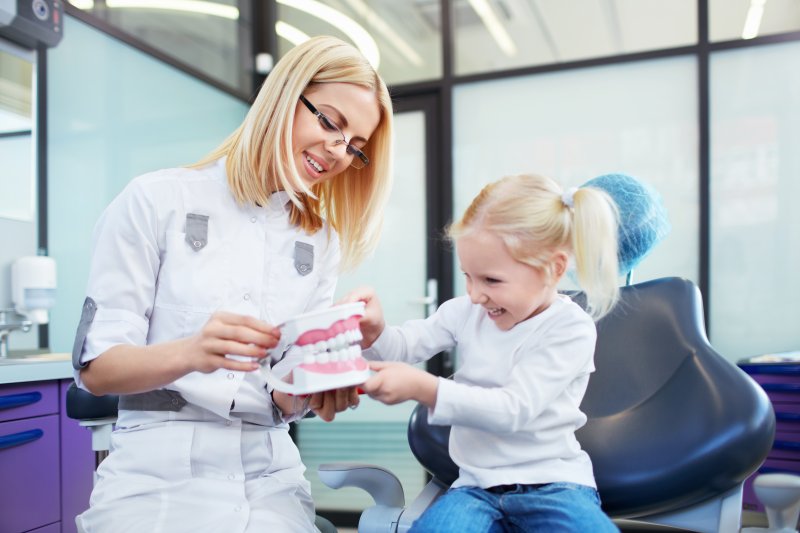 Child playing with an oversized denture