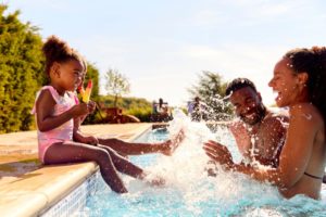 children splashing their parents in a pool