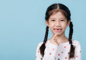 Little girl pointing at her missing baby teeth